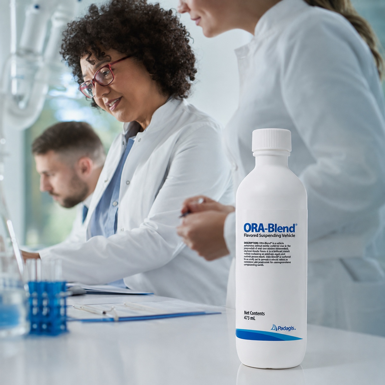Pharmacy professionals working in a laboratory with an ORA-Blend bottle in the foreground